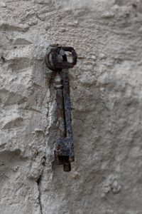 Twee oude sleutels die aan een spijker in de muur hangen
